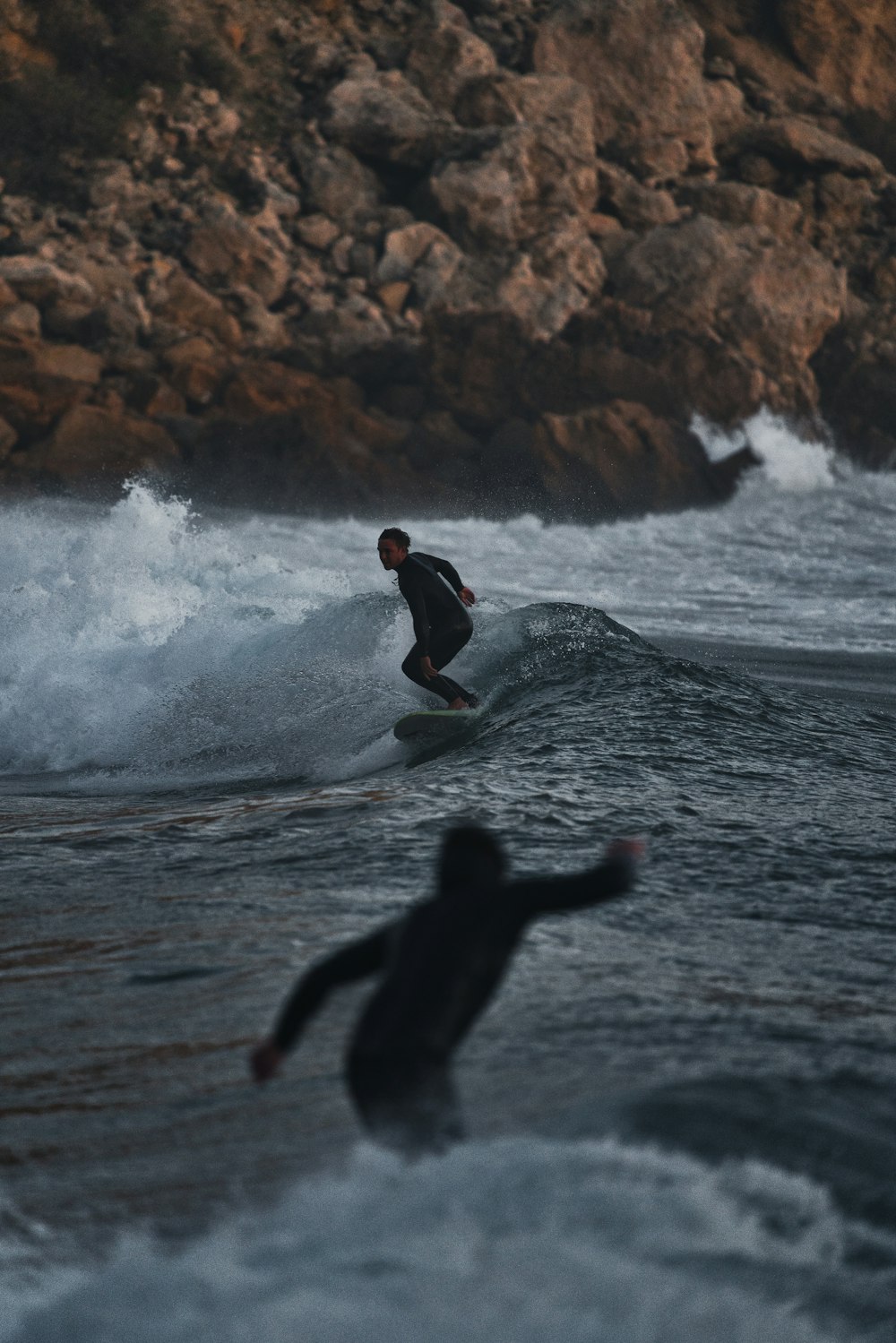 a man riding a wave on top of a surfboard