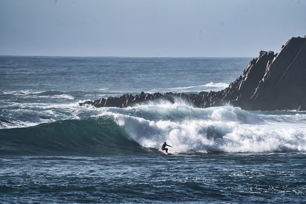 a person riding a wave on top of a surfboard