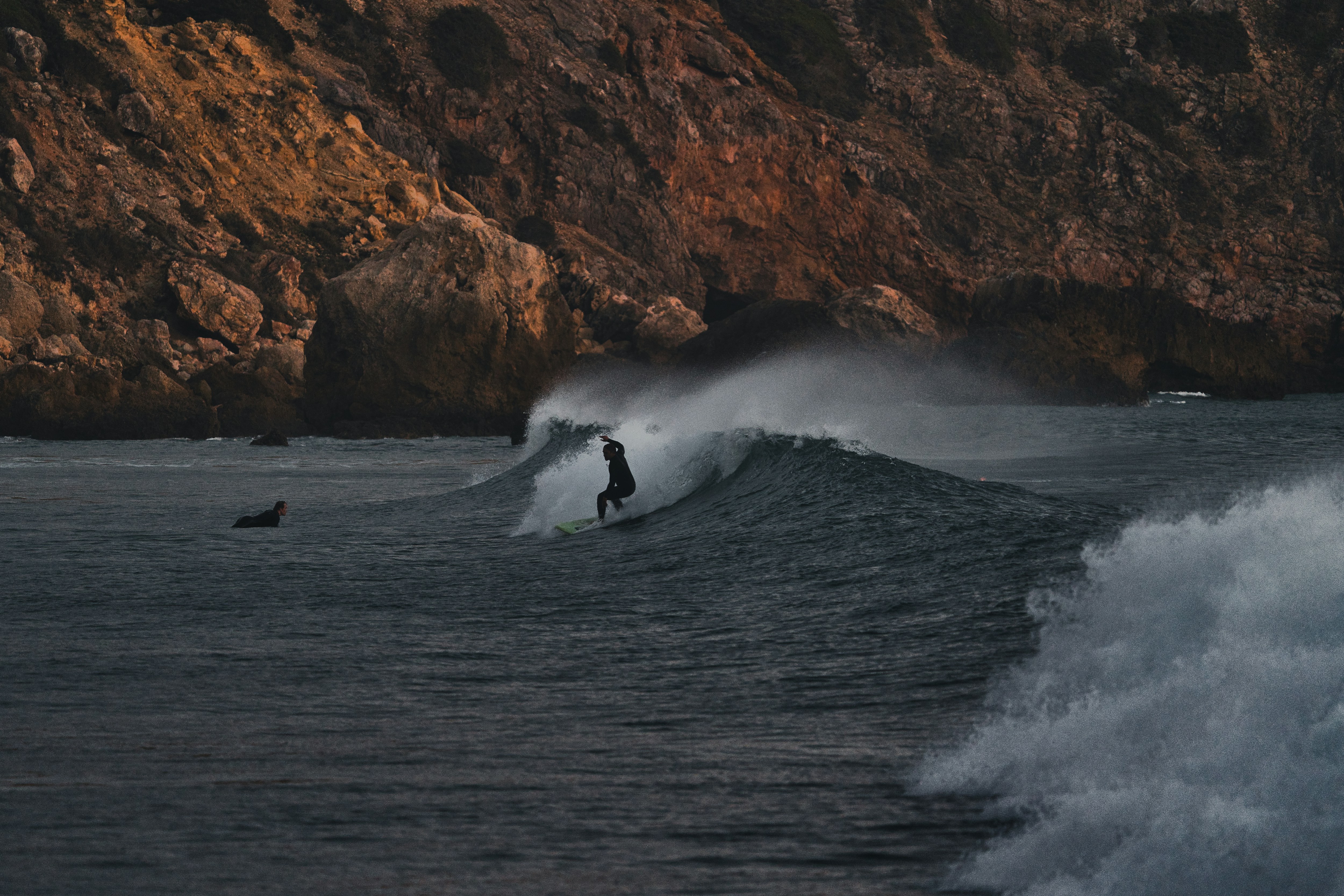 a man riding a wave on top of a surfboard