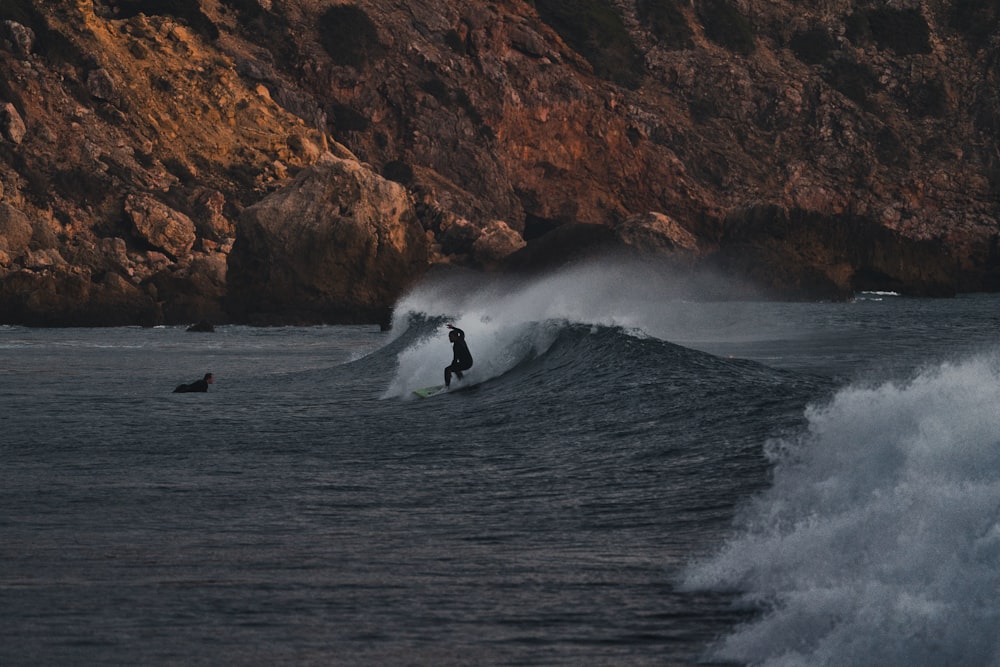 a man riding a wave on top of a surfboard