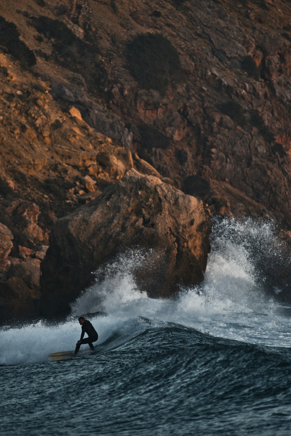 a man riding a wave on top of a surfboard