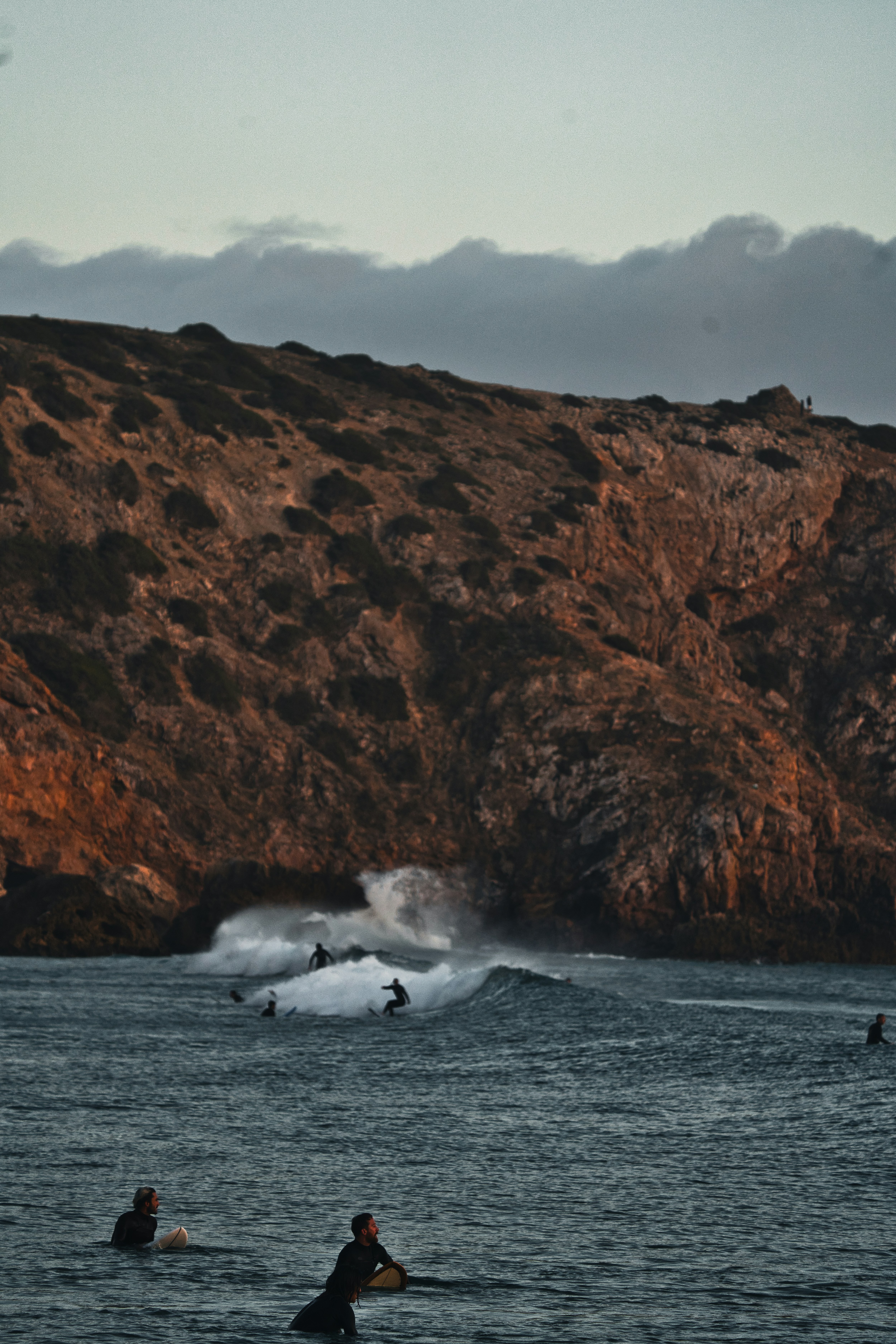 a group of people riding surfboards on top of a body of water