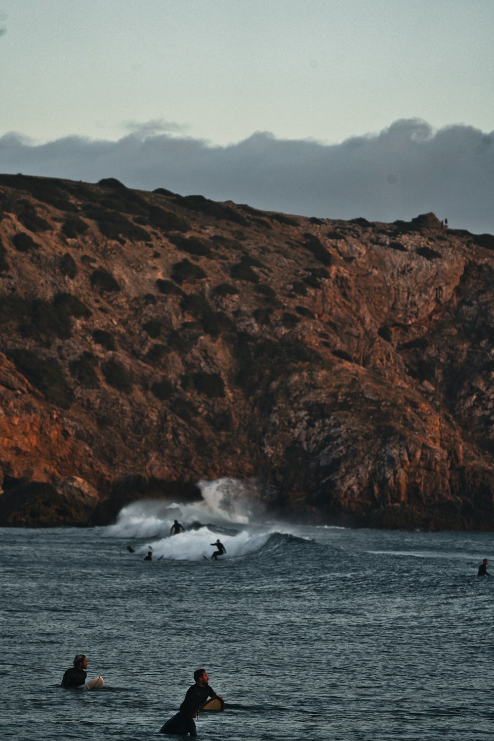 a group of people riding surfboards on top of a body of water