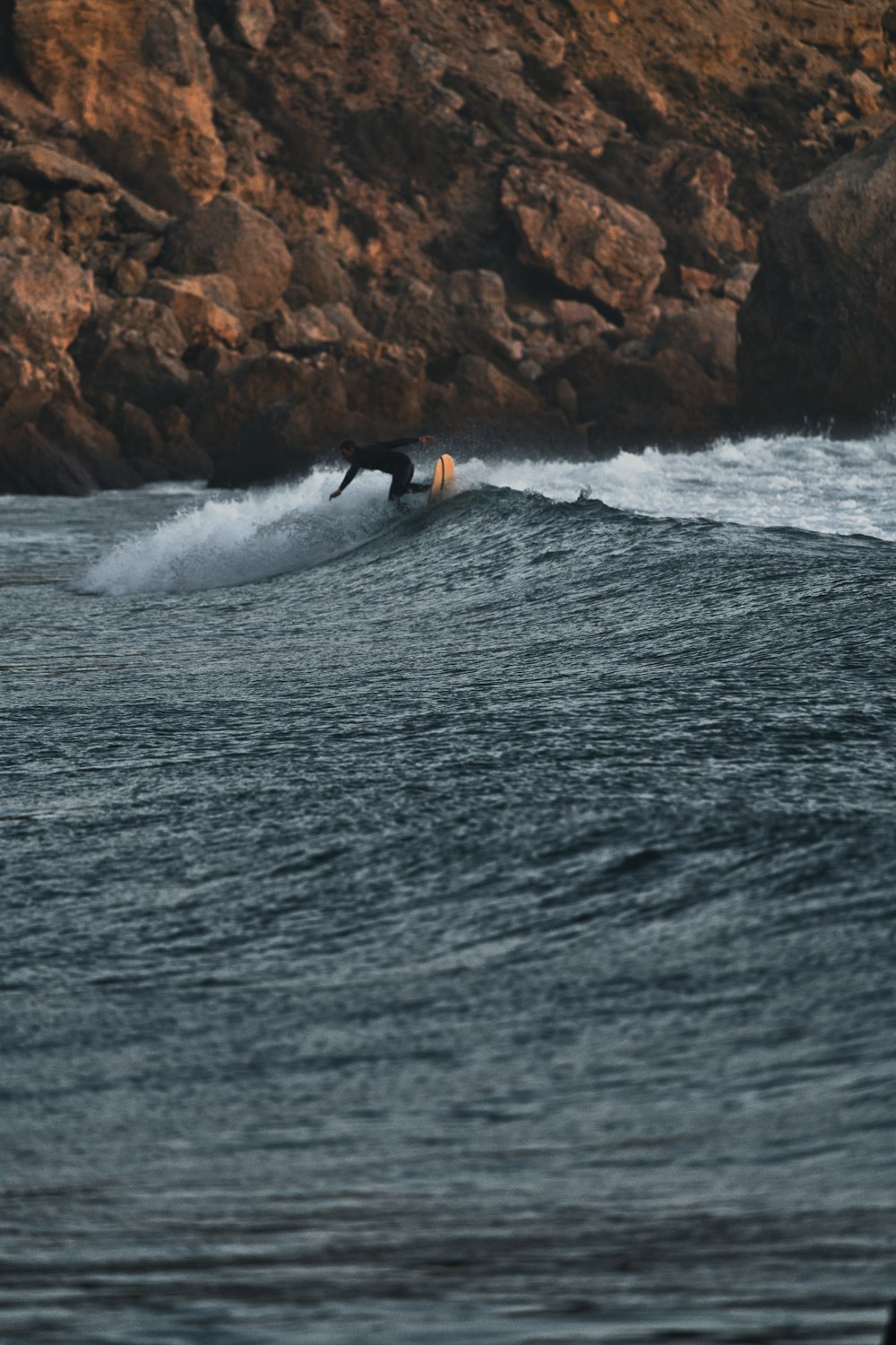 a man riding a wave on top of a surfboard