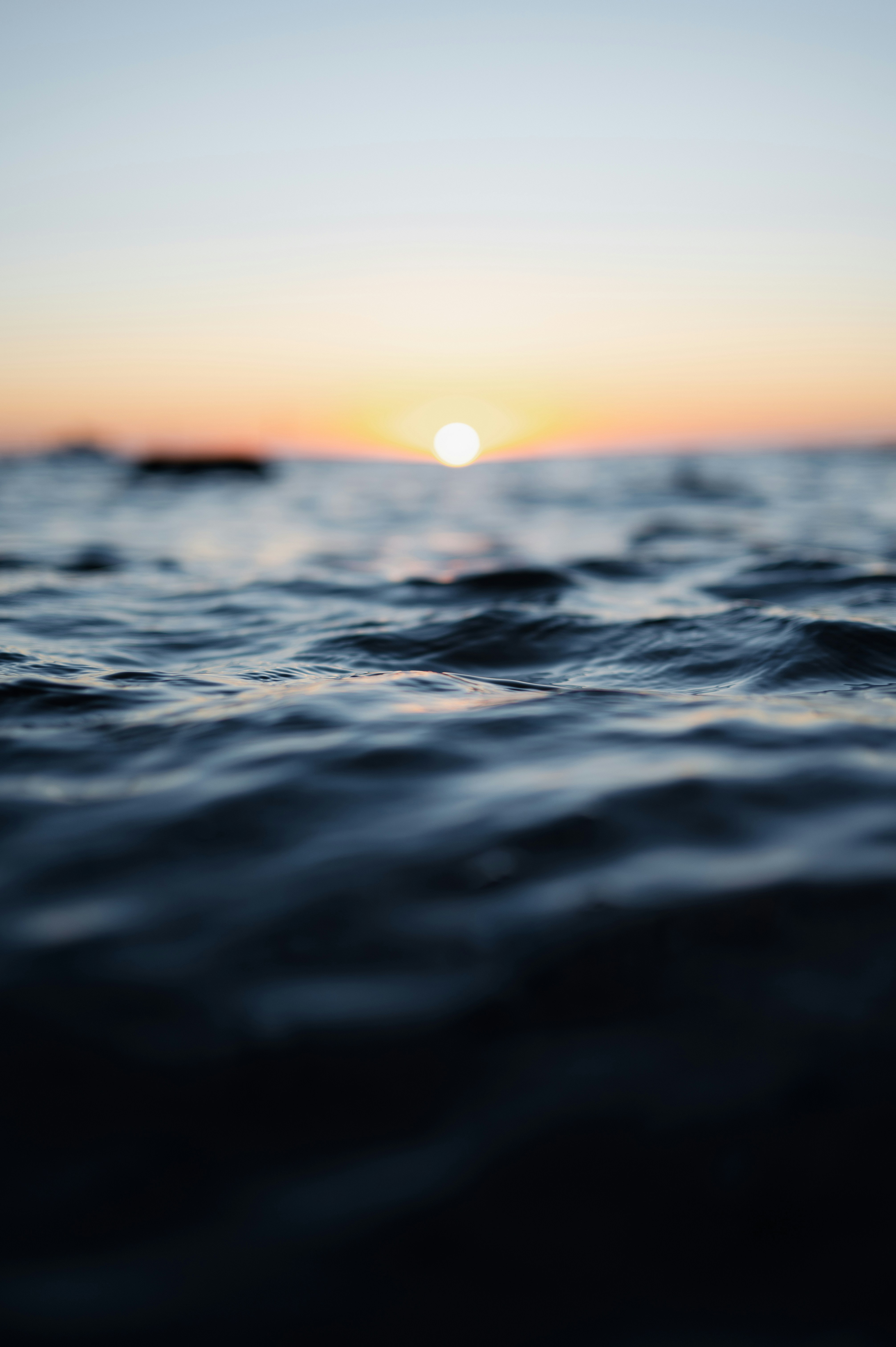 the sun is setting over the ocean water