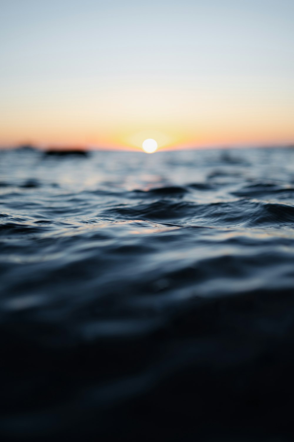 o sol está se pondo sobre a água do oceano