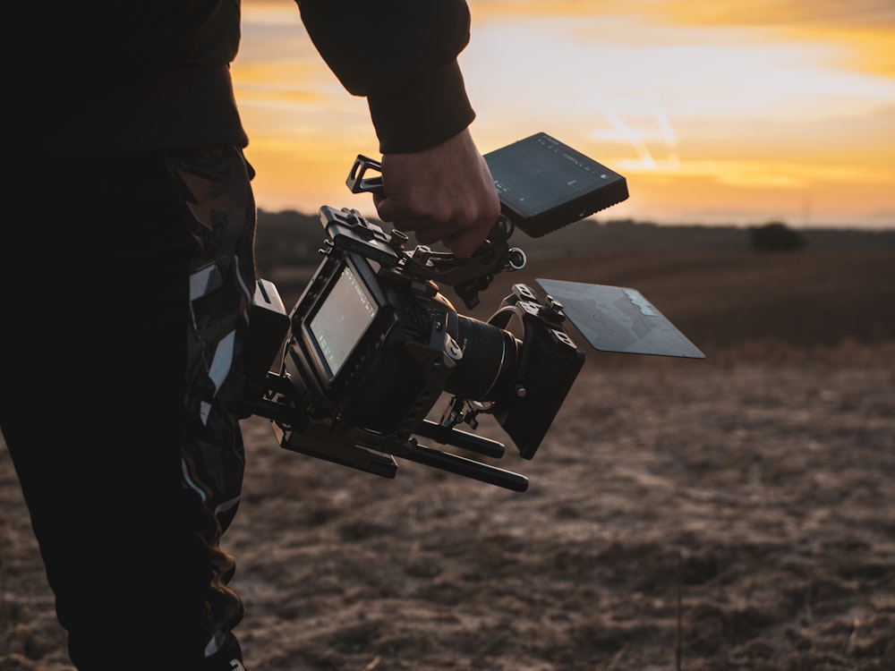 a person holding a camera in a field