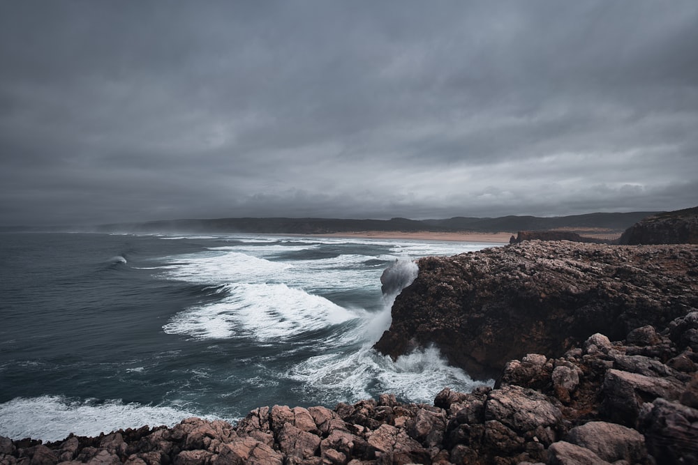 a large body of water near a rocky shore