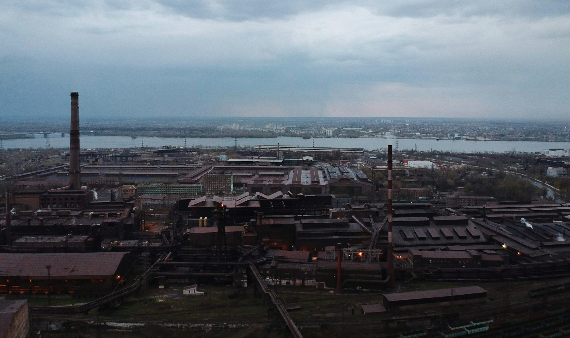 a view of an industrial area with a river in the background
