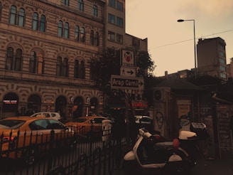 A professional taxi waiting outside a stylish Paris hotel at sunset, ready to welcome travelers.