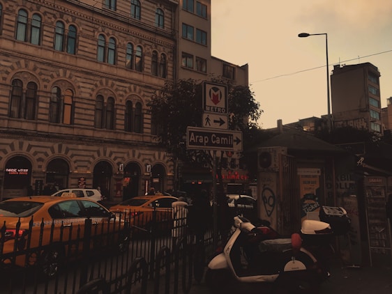 A professional taxi waiting outside a stylish Paris hotel at sunset, ready to welcome travelers.