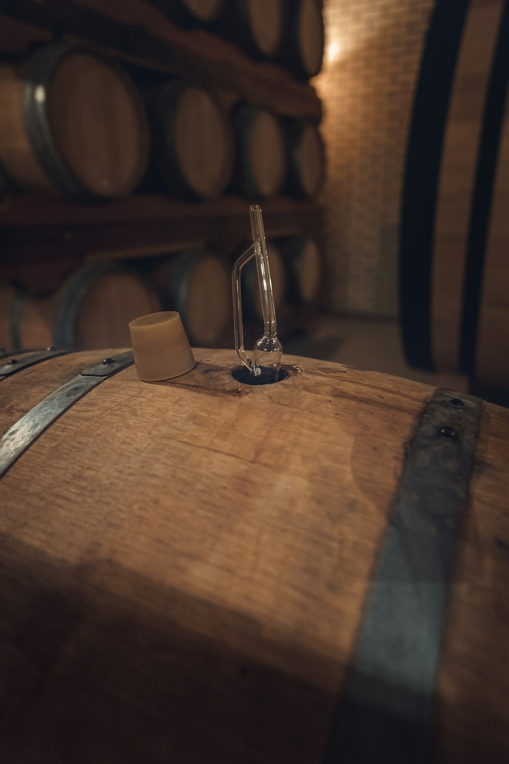 a bottle of wine sitting on top of a wooden barrel