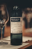 a bottle of wine sitting next to a glass of wine