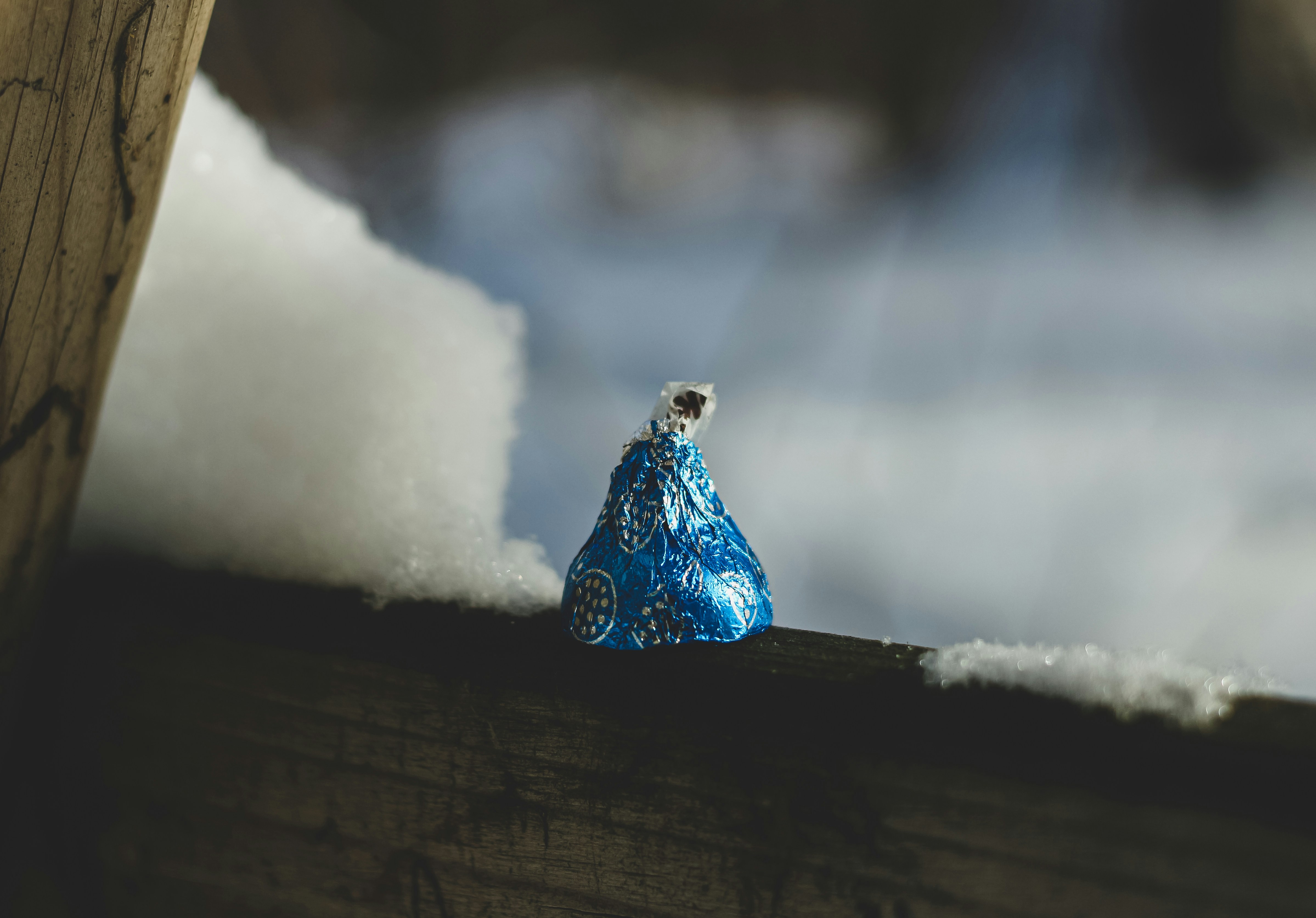 a blue bag sitting on top of a wooden fence