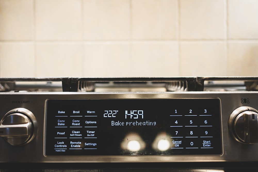 a close up of a stove with a clock on it