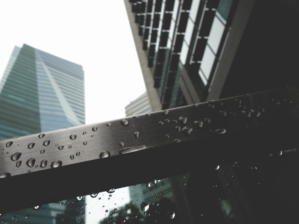 a close up of a metal object with buildings in the background