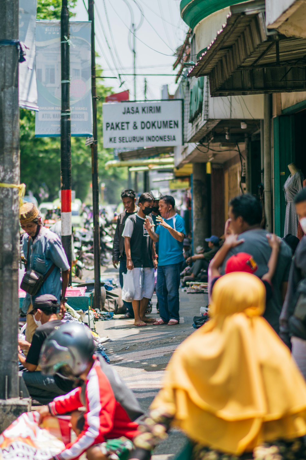 a group of people walking down a street next to shops