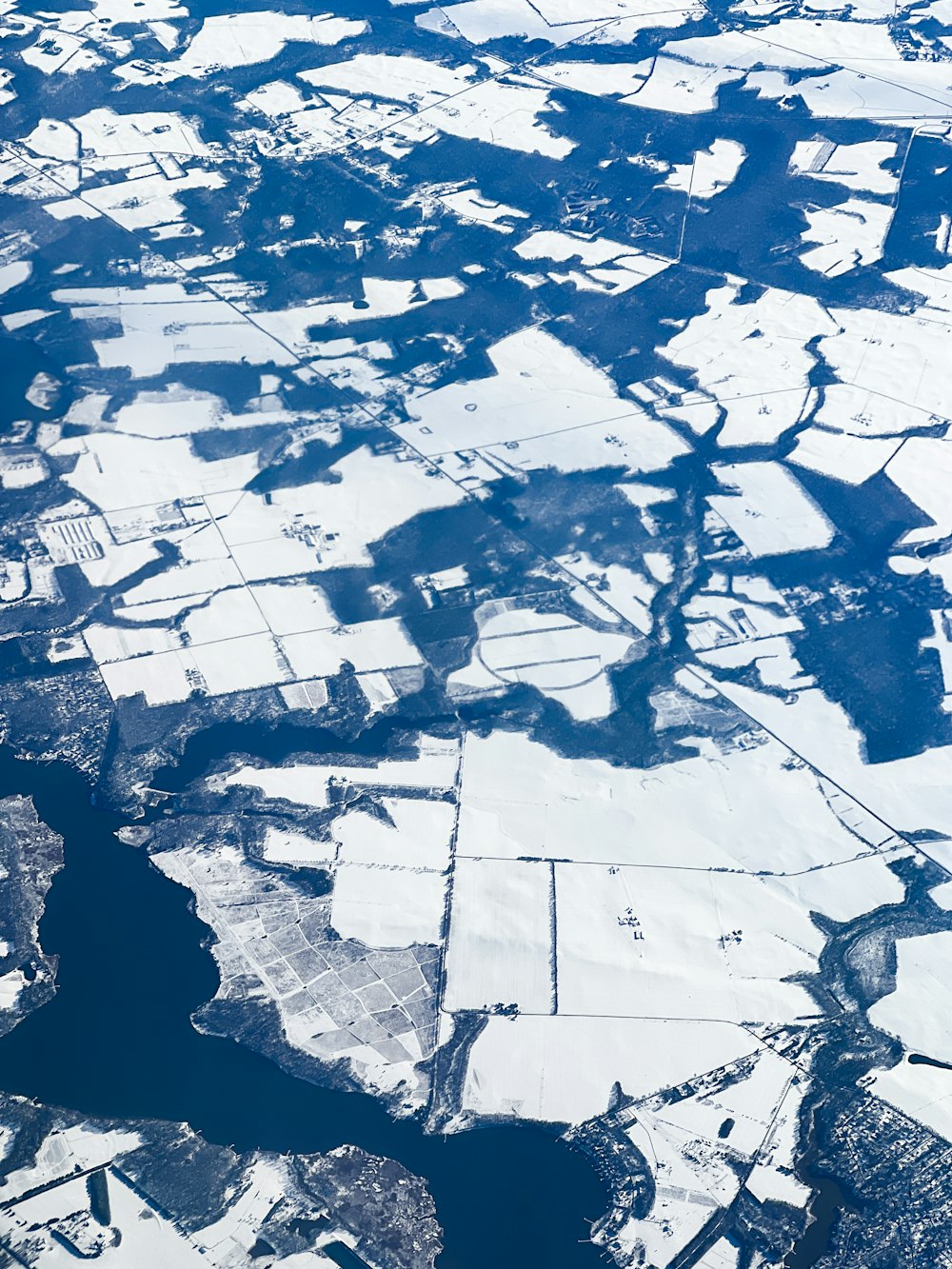 an aerial view of snow covered land and water