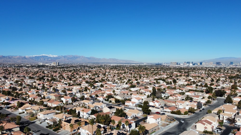 an aerial view of a city with mountains in the background