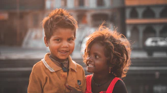 A warm, bright image of two children happily playing together in a sunlit park, symbolizing harmony and care.