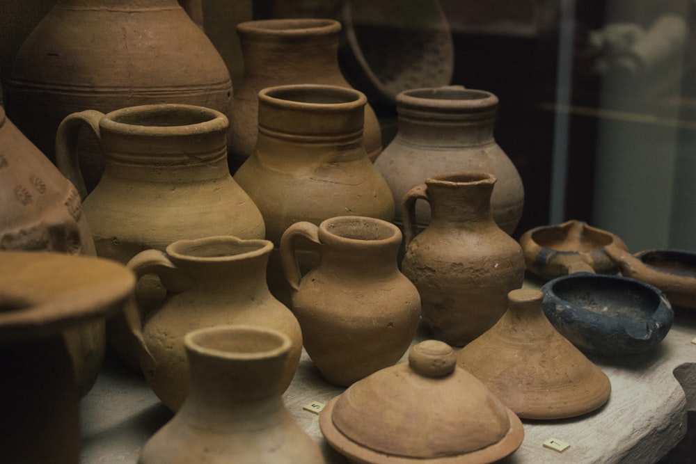 a table topped with lots of brown vases