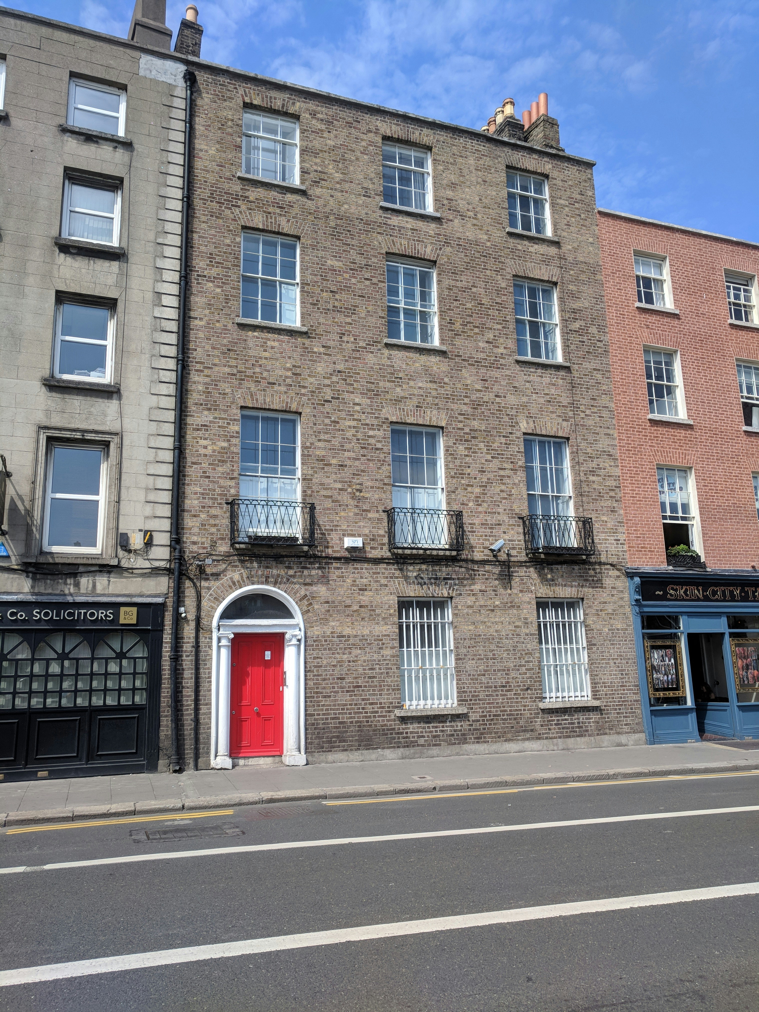 a tall brick building with a red door