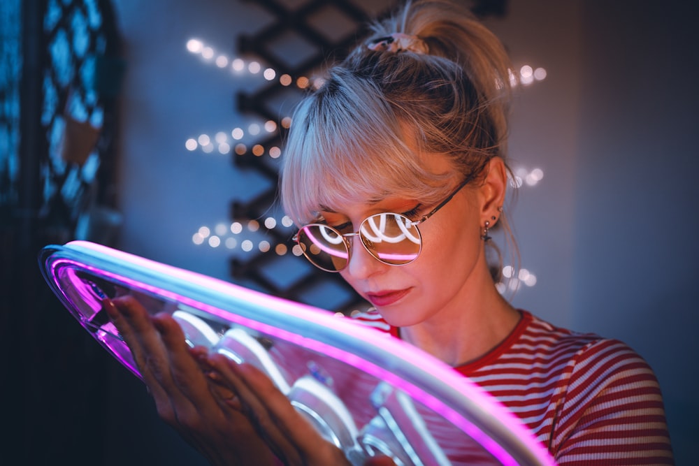 a woman wearing glasses looking at a tablet