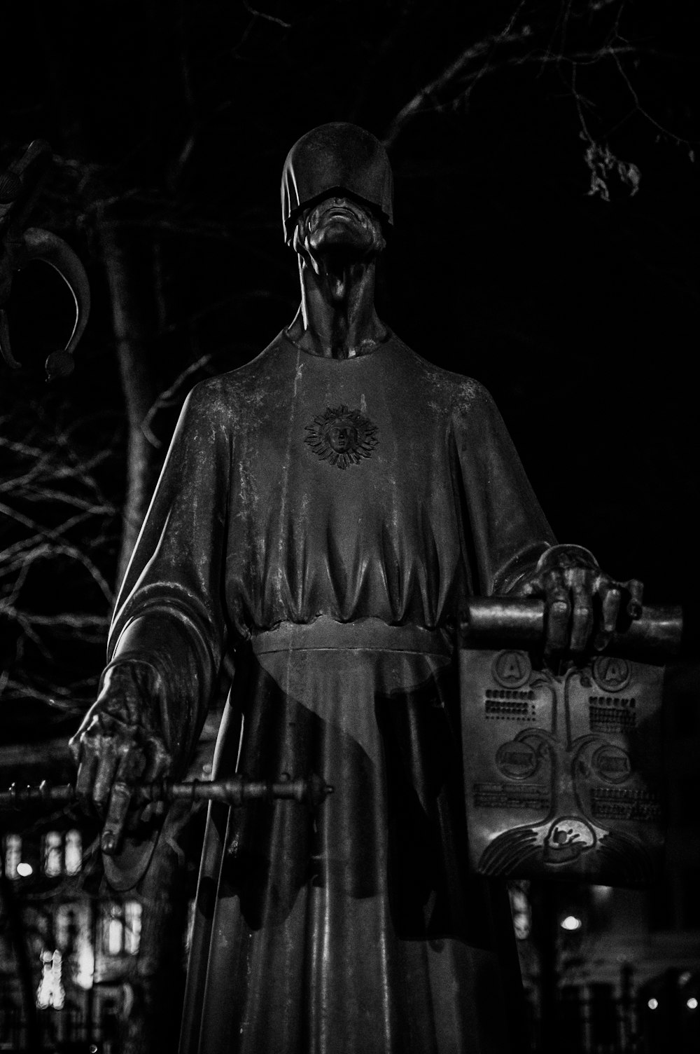 une photo en noir et blanc d’une statue d’un homme tenant une borne d’incendie