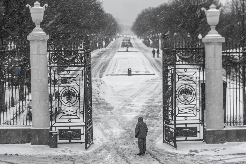 雪の中で門の前に立つ人