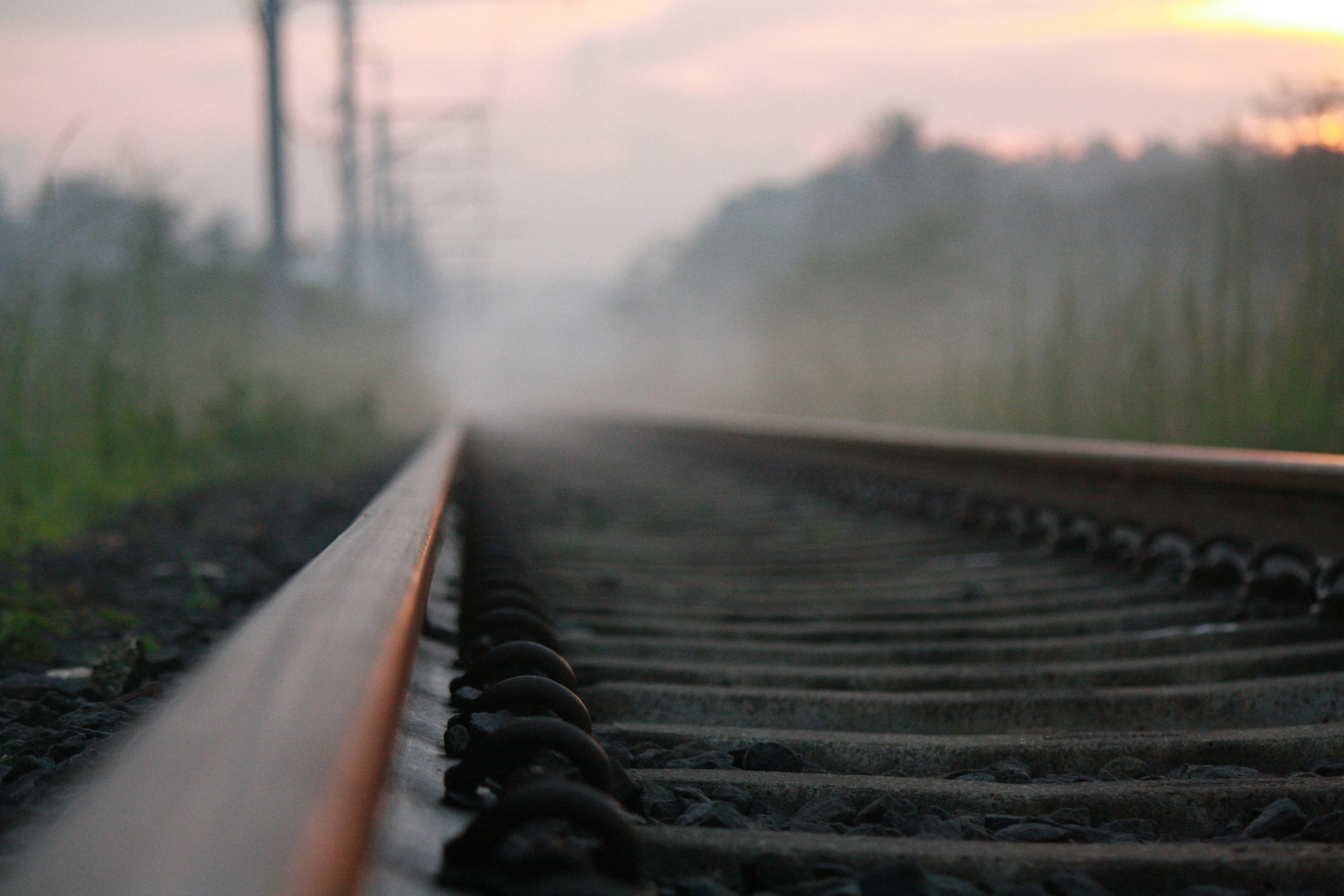 a train track with a foggy sky in the background