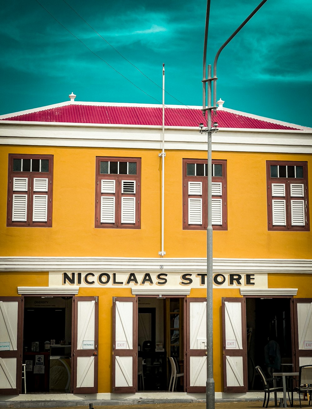 a tall yellow building with a red roof