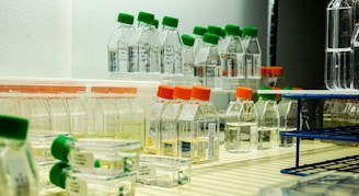 a row of bottles filled with liquid sitting on a shelf