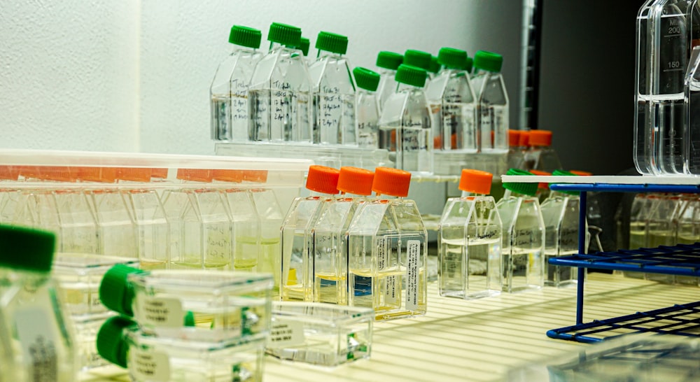 a row of bottles filled with liquid sitting on a shelf