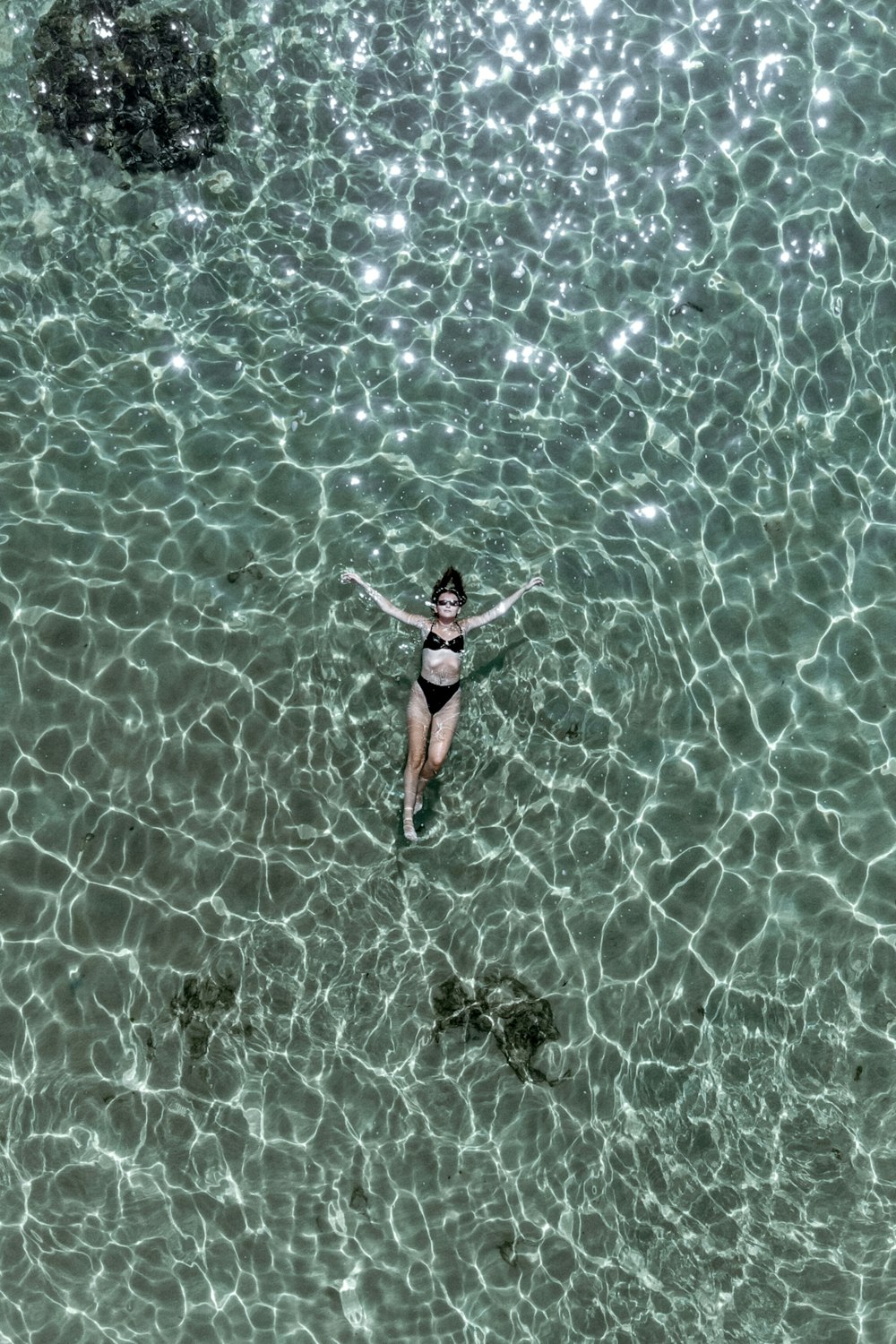 a woman in a bikini floating in a body of water