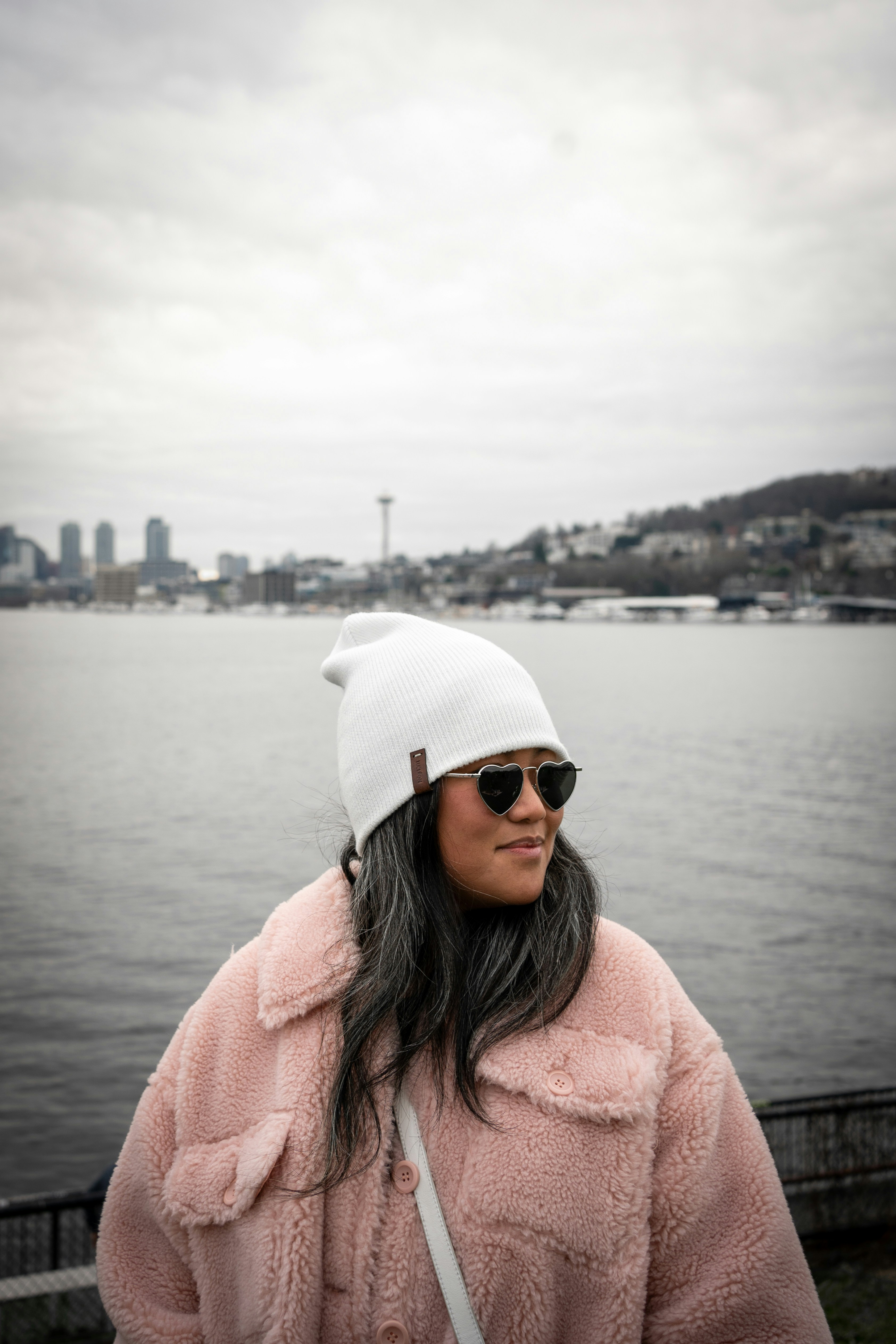 a woman wearing a pink coat and a white hat