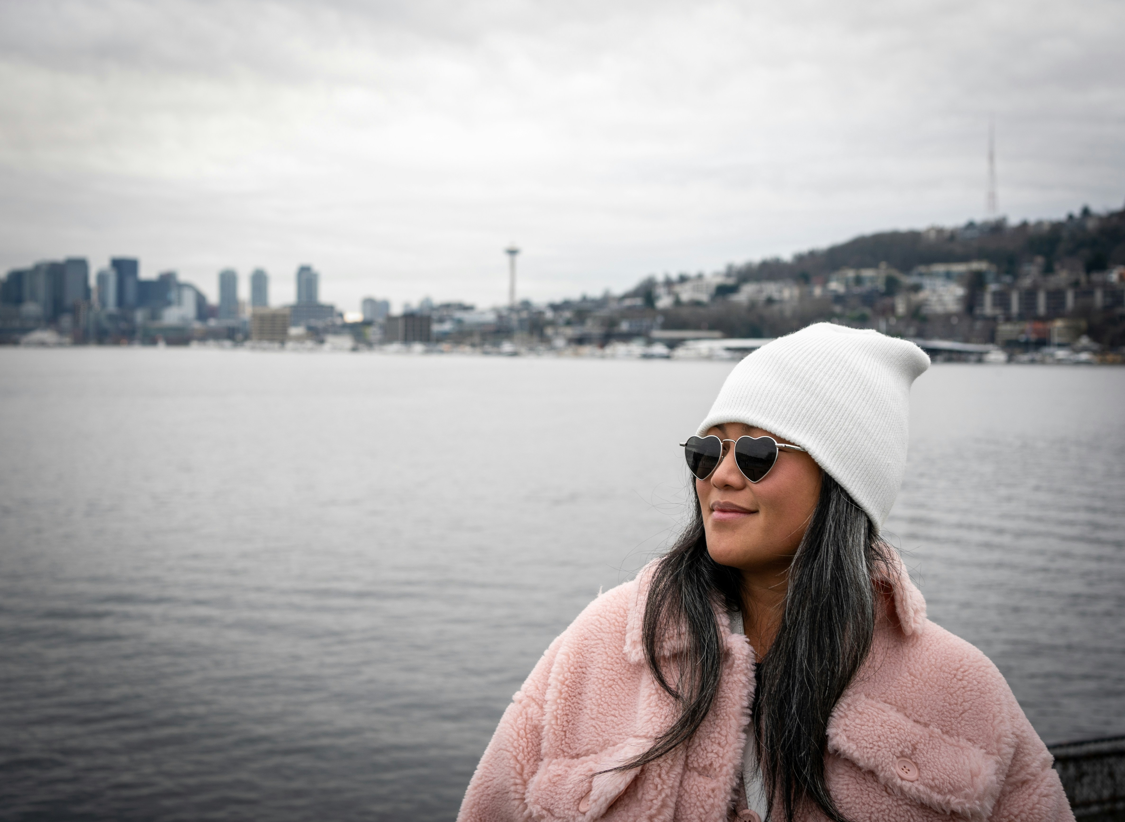 a woman wearing a pink coat and a white hat