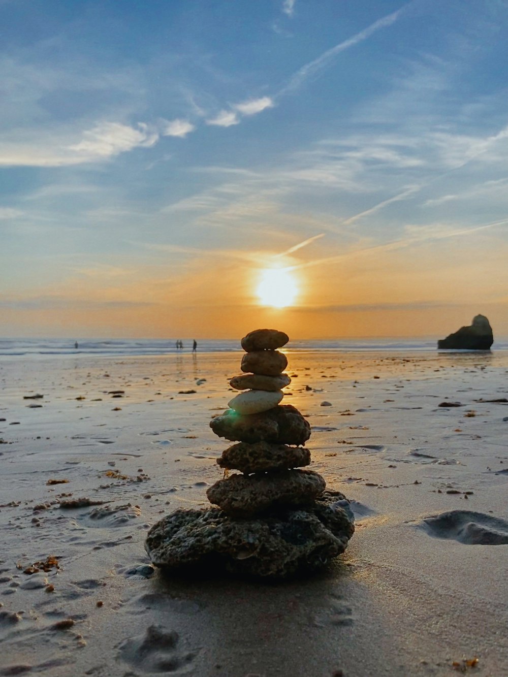 a stack of rocks sitting on top of a sandy beach