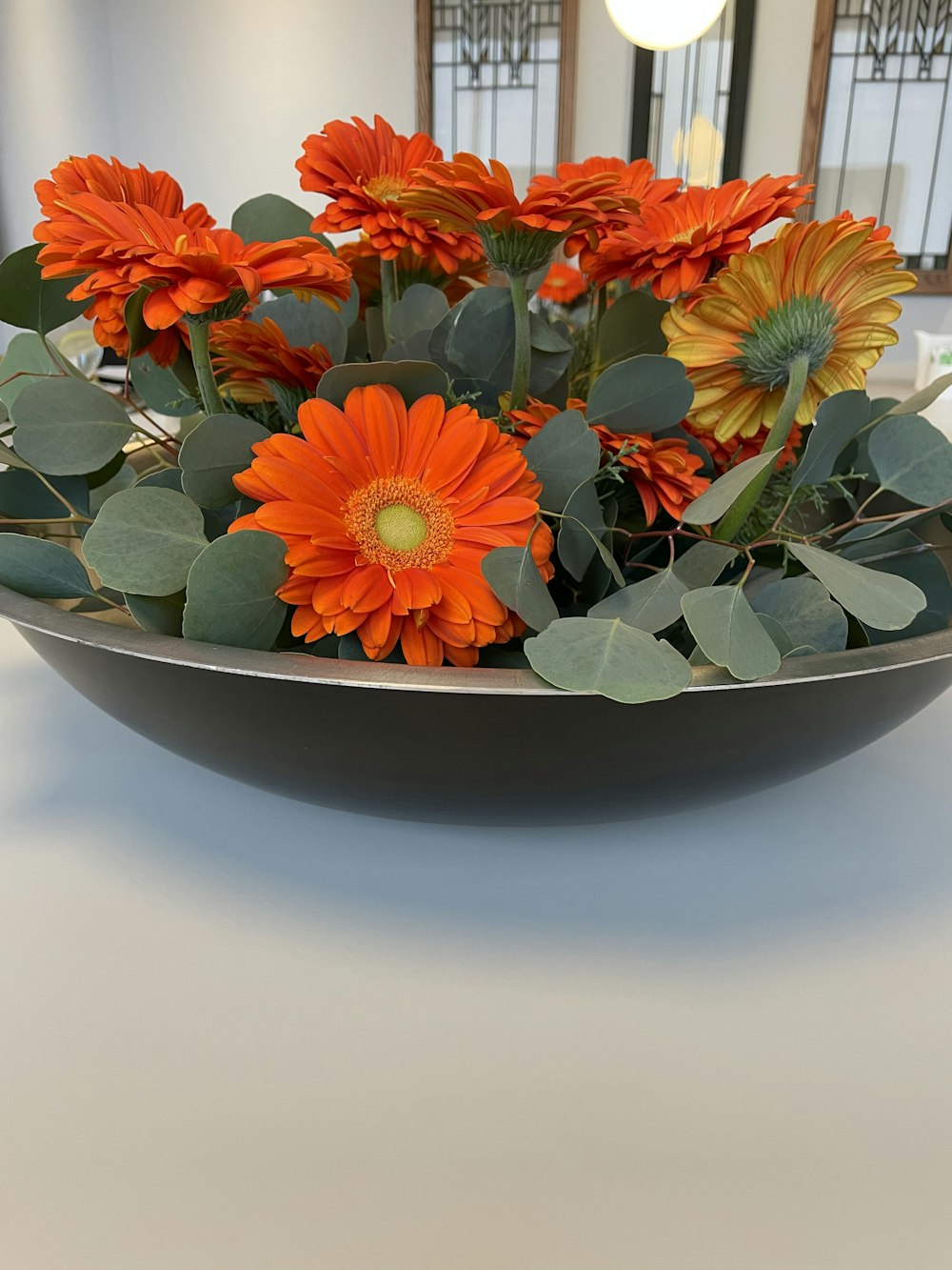 a bowl filled with orange flowers on top of a table