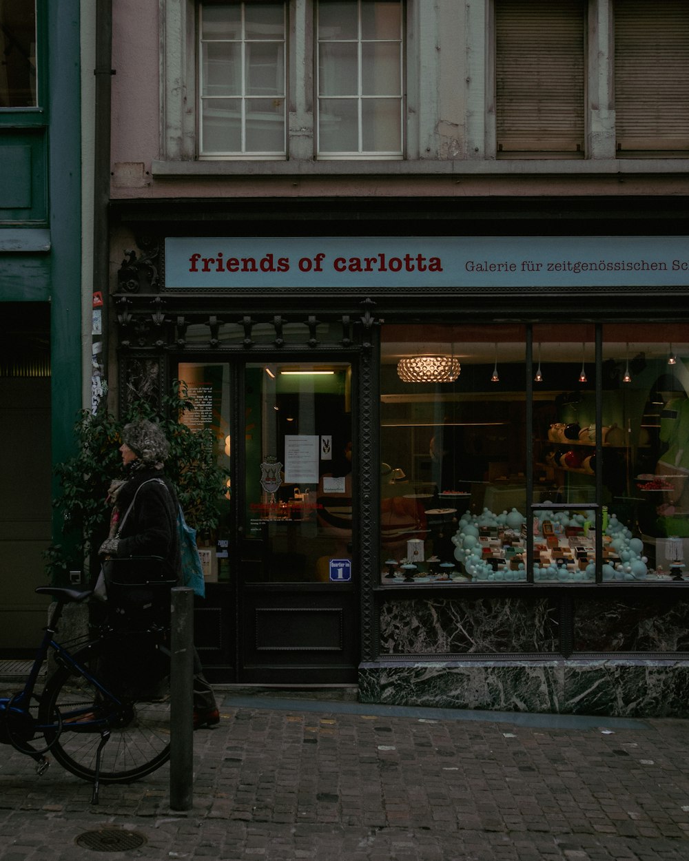 a person walking past a store front with a bicycle parked in front of it