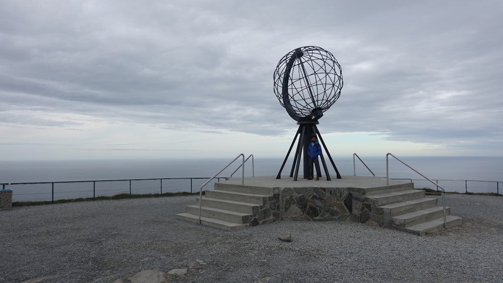 a statue of a globe on top of a hill