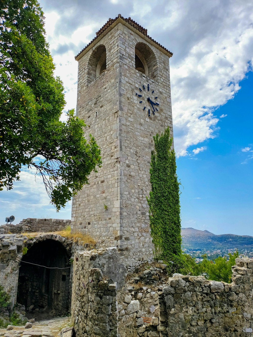 uma torre de pedra com um relógio no topo dela