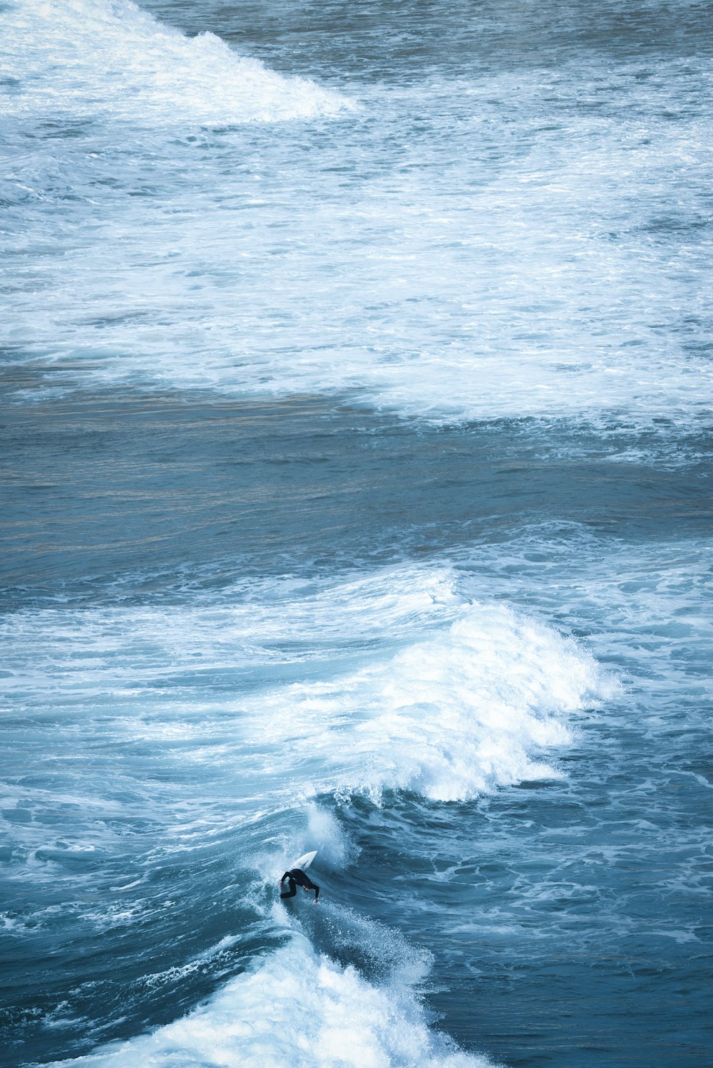 a man riding a wave on top of a surfboard