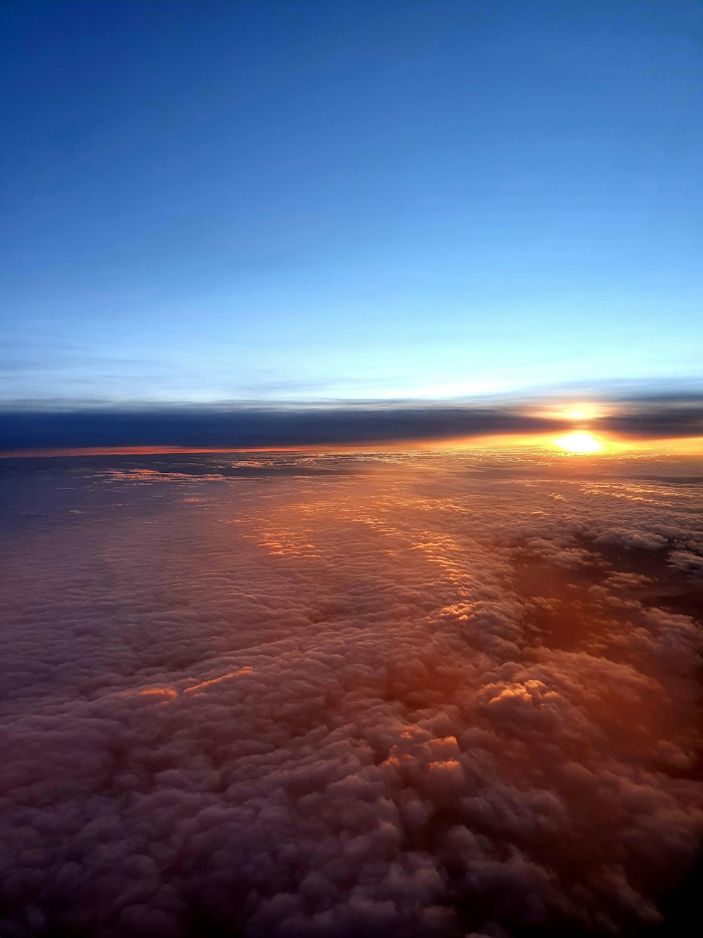 the sun is setting over the clouds in the sky