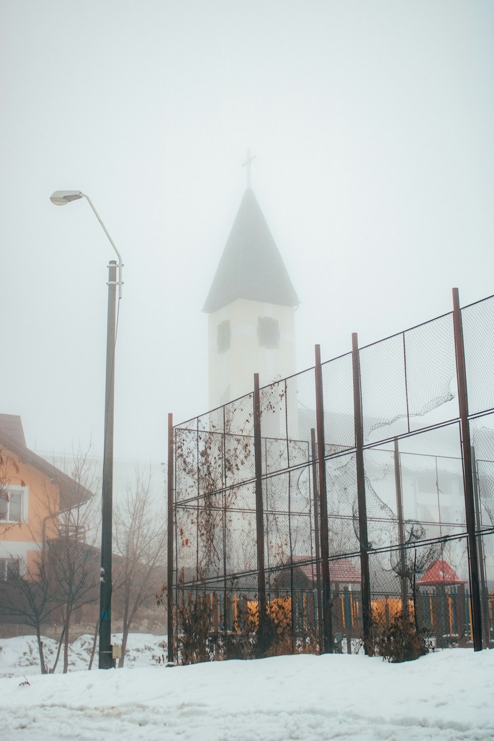 a church with a steeple on a snowy day