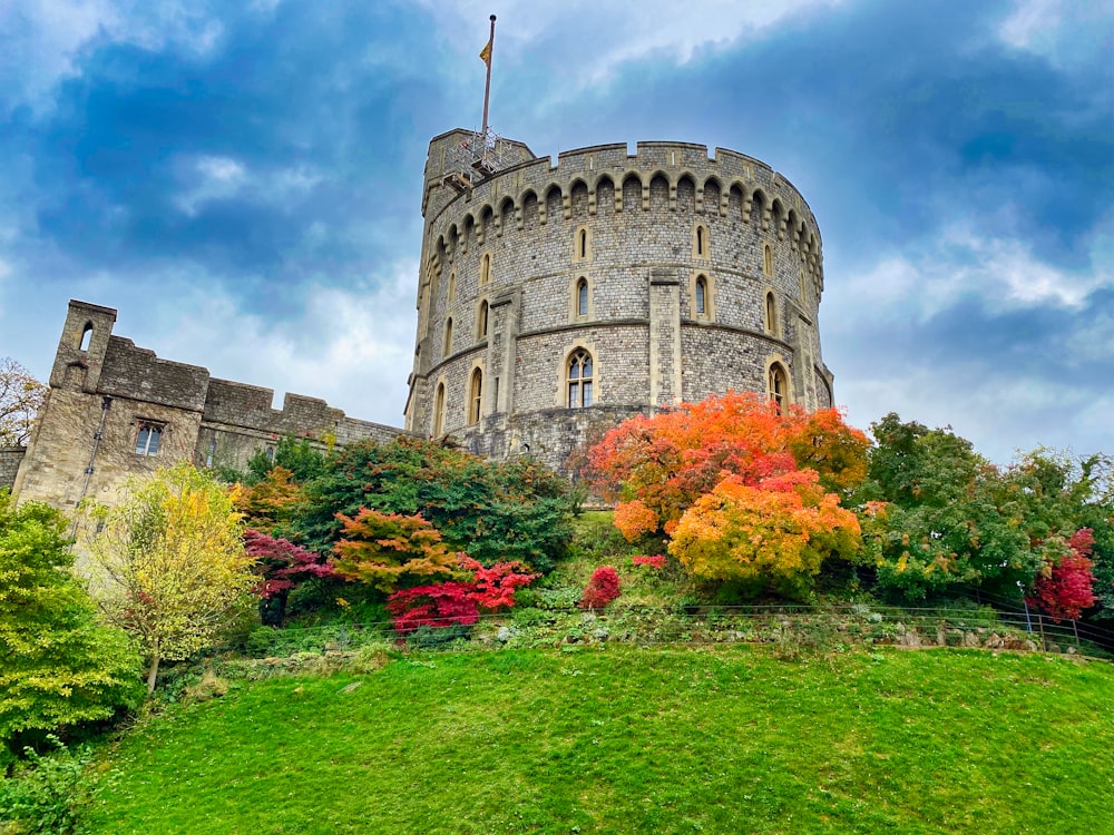 a castle with a lush green field next to it