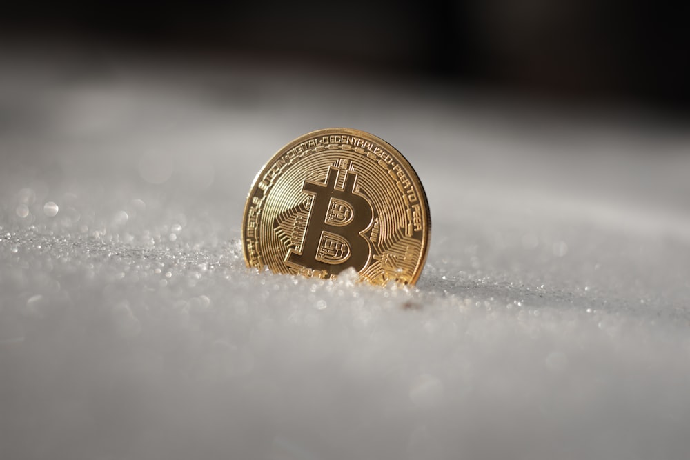a bit coin sitting on top of snow covered ground
