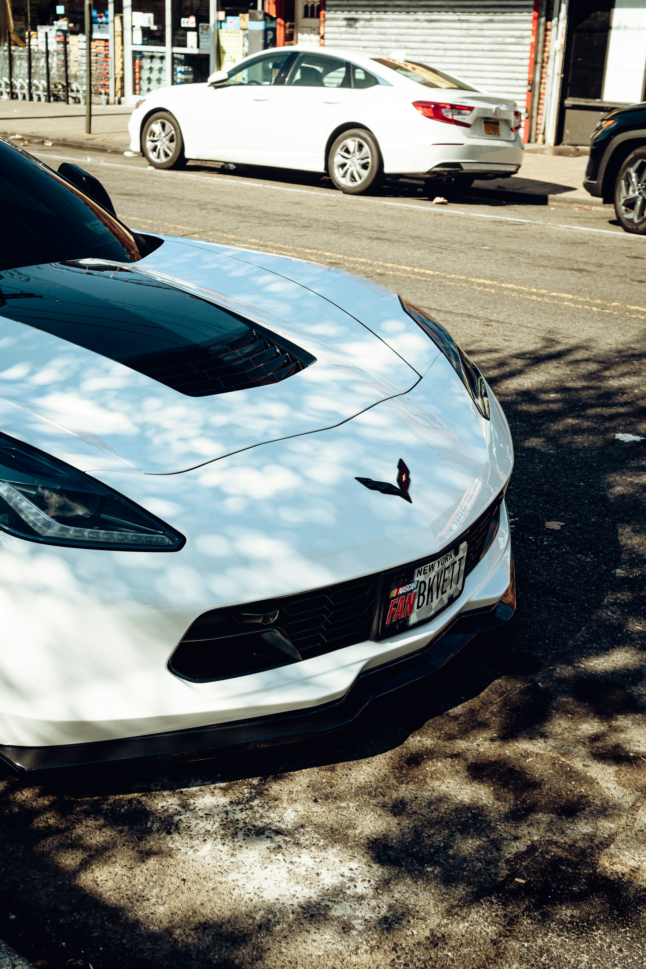 a white sports car parked on the side of the road