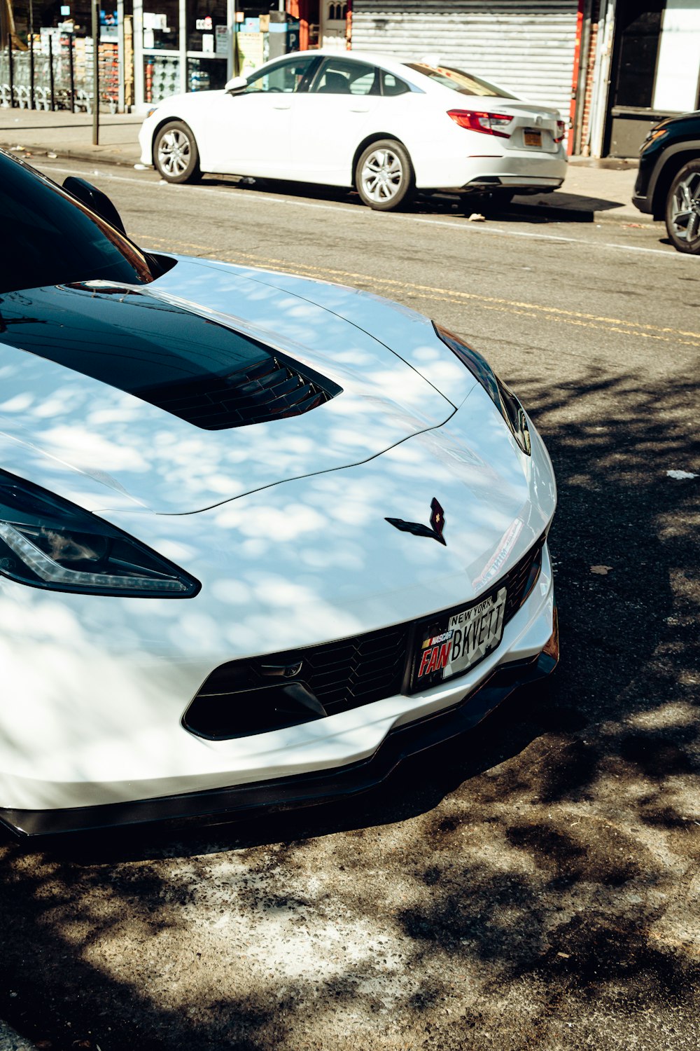 a white sports car parked on the side of the road