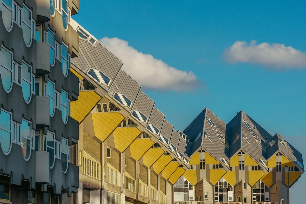 a row of multi - story buildings with a clock on each of them