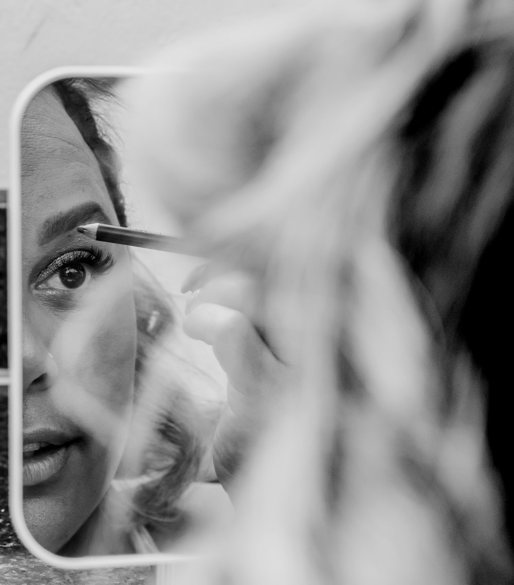 a woman is looking at her reflection in a mirror